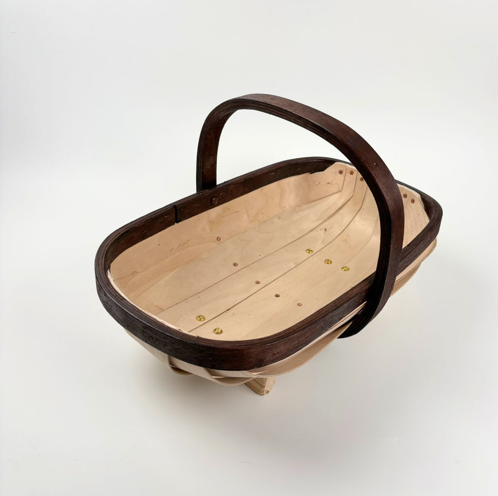 Wooden trug with a dark brown handle on a light gray background